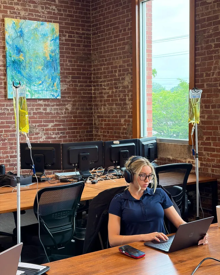 A client working at her desk during an IV drip