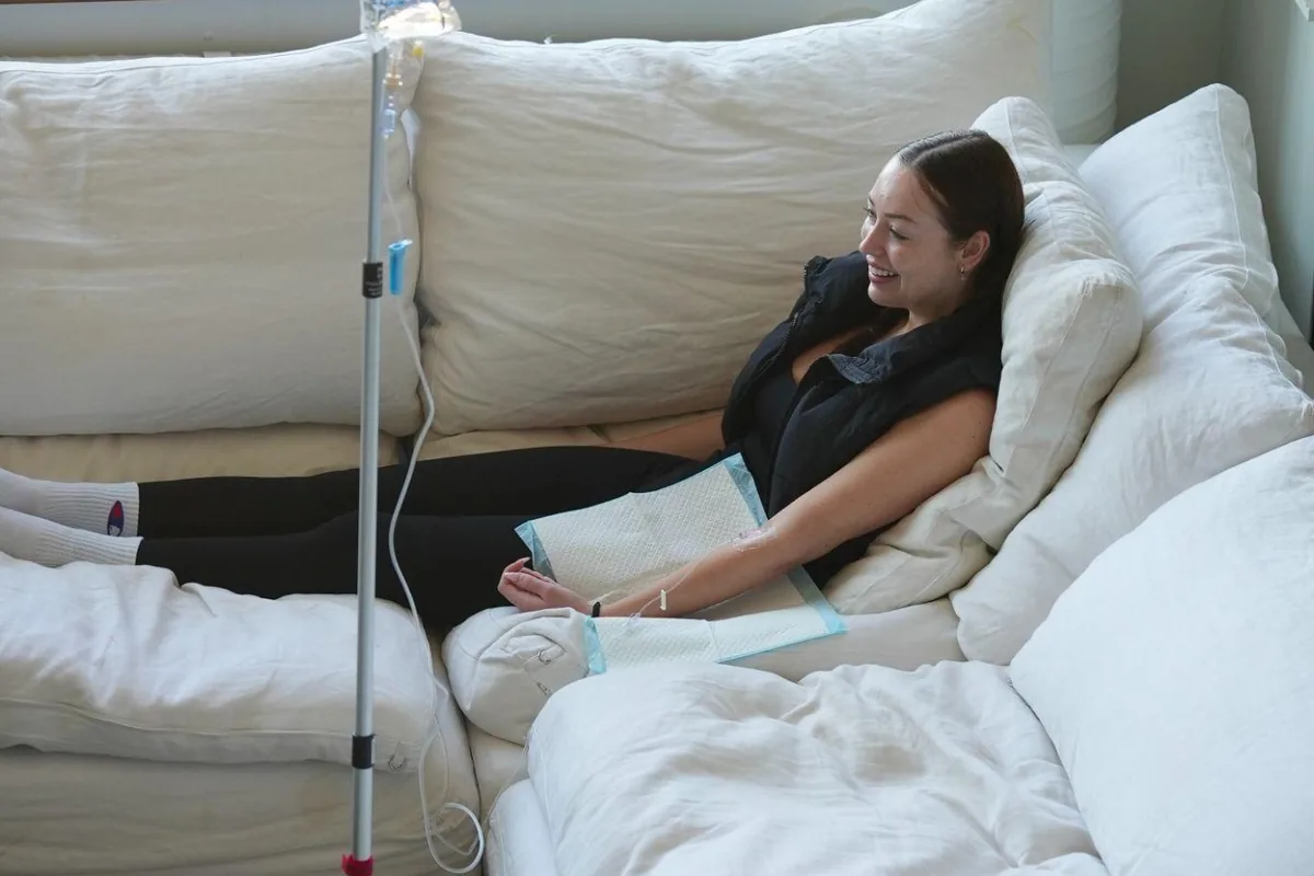 A client receiving an IV drip at home on her own sofa